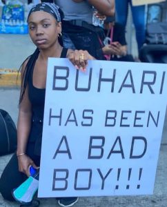 lady holds "Buhari has been a bad boy'' banner